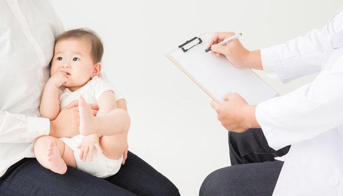 医師の検診を受ける母子の写真